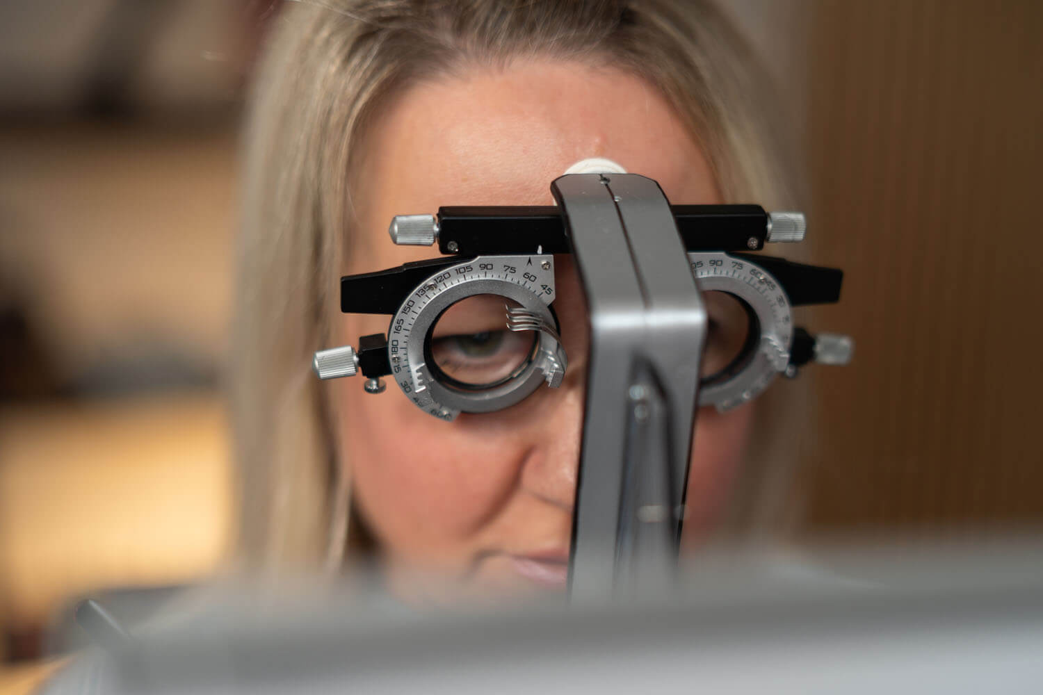 Frau schaut durch ein Optikergerät