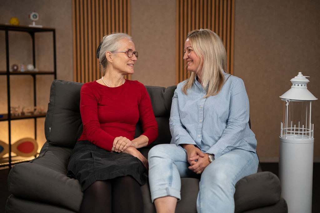 Deine Expertinnen: Jeanette Scheich und Gabriele Ueltzen sitzen auf einer Couch.